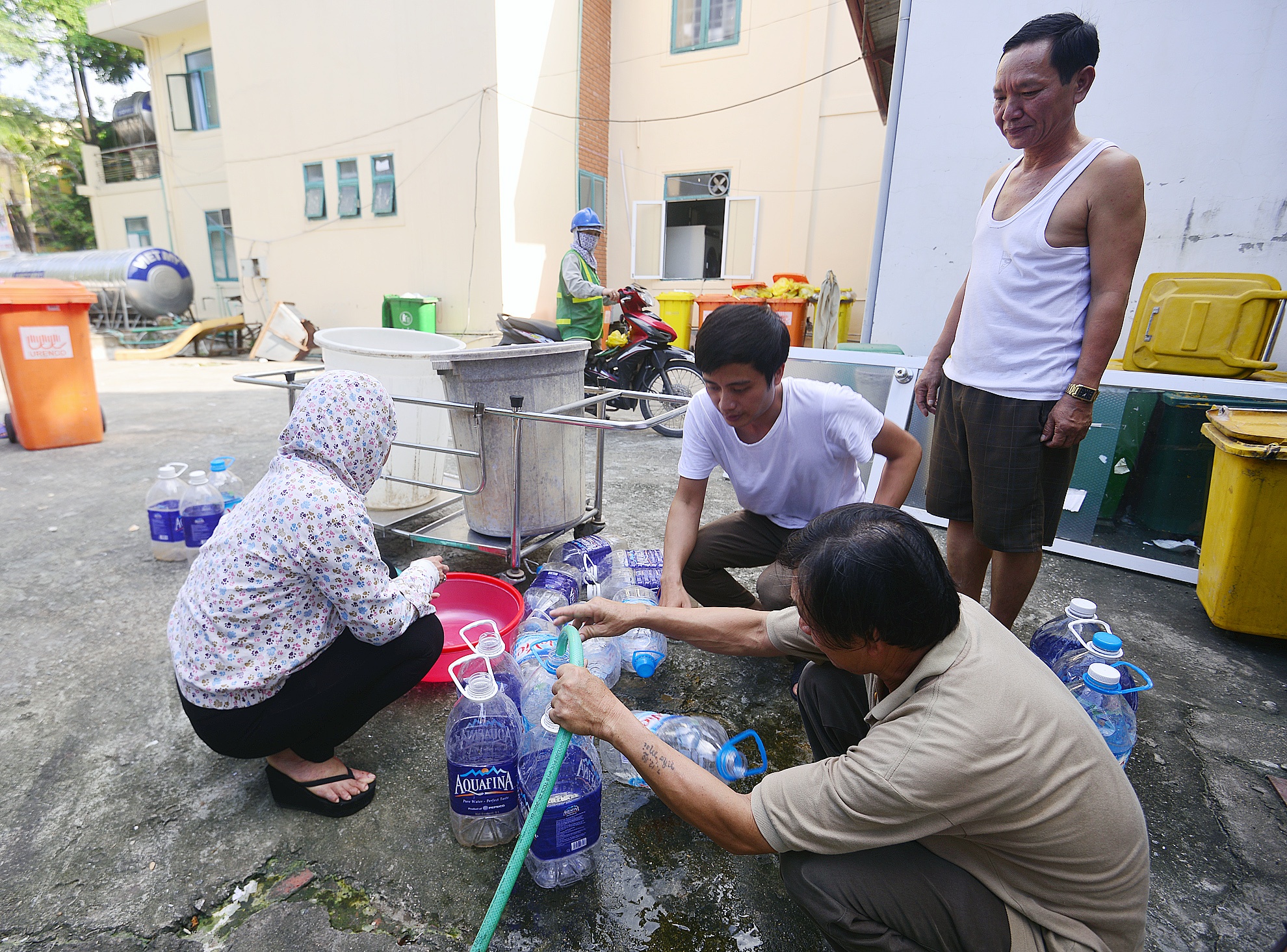 Bac si, benh nhan xach can di lay nuoc hinh anh