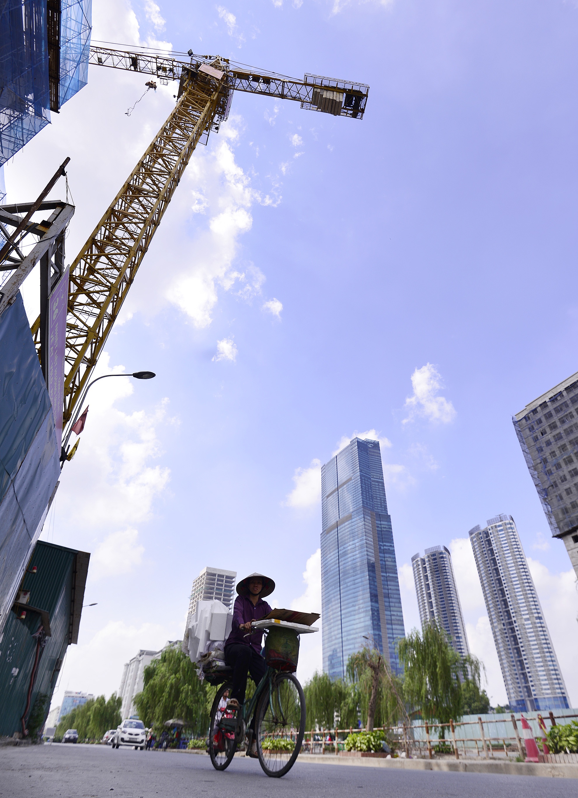 Người dân đi trên đường Nguyễn Chánh không khỏi lo lắng khi thấy chiếc cẩu cao hàng chục mét lơ lửng trên đầu.