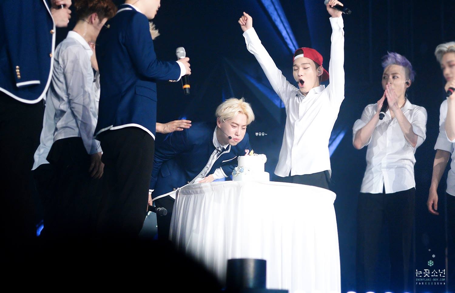 Suho hạnh phúc thổi nến sinh nhật muộn trên sân khấu. 