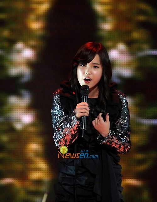 Lúc mới ra mắt, IU chú trọng vào giọng hát hơn là hình ảnh. Dù đã khéo léo chọn bộ đồ kín mít, tối màu, trông cô vẫn tương đối tròn trĩnh. Ảnh: newsen