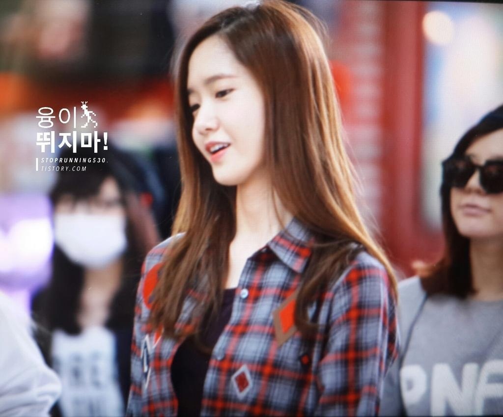 Cô ăn mặc khá giản dị, với áo sơ mi sọc kèm áo đen bên trong.