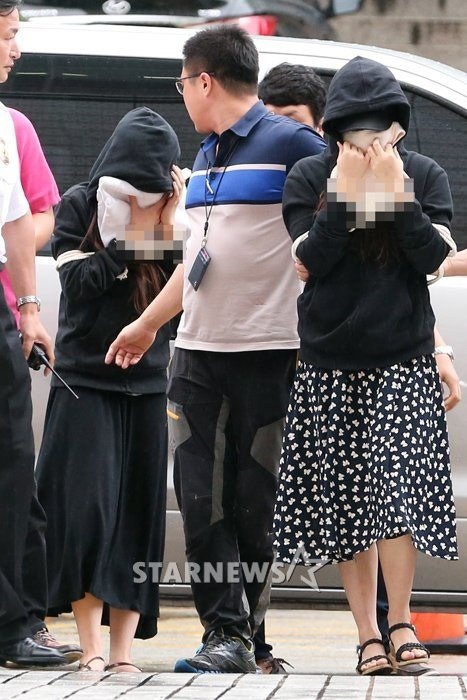 Dahee (váy hoa) và cô B bị áp giải tới tòa hôm 3/9.