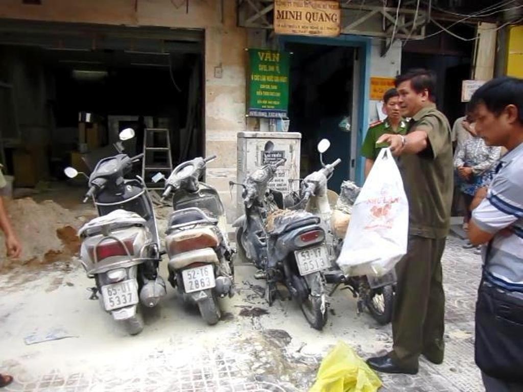 Nguoi phu nu do xang dot 4 xe may giua Sai Gon hinh anh