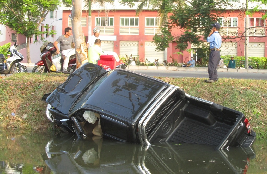 O to lao xuong kenh, 4 nguoi keu cuu trong xe hinh anh