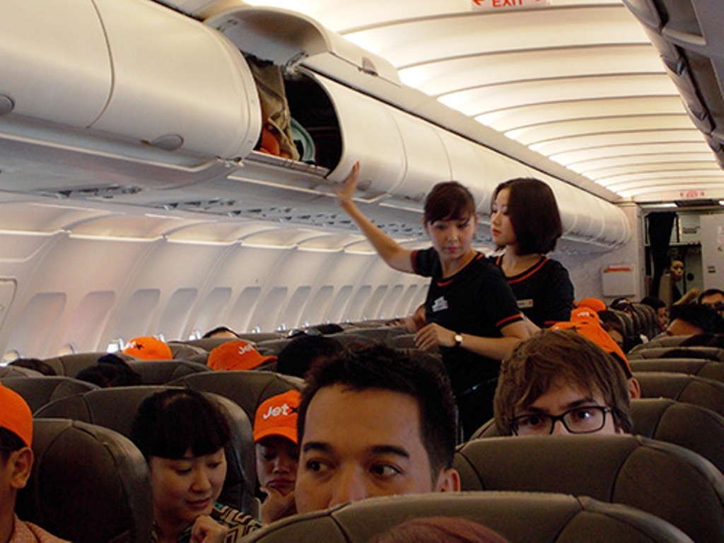 Tiếp viên kiểm tra lại giá để hành lý của khách trước khi máy bay cất cánh.