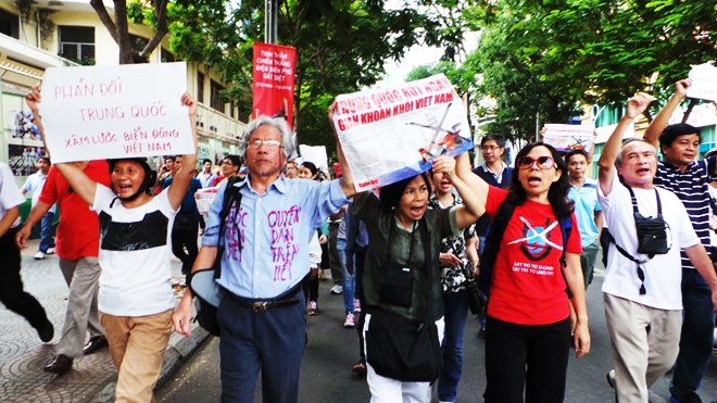 Cờ Tổ quốc tung bay trong đoàn diễu hành. 