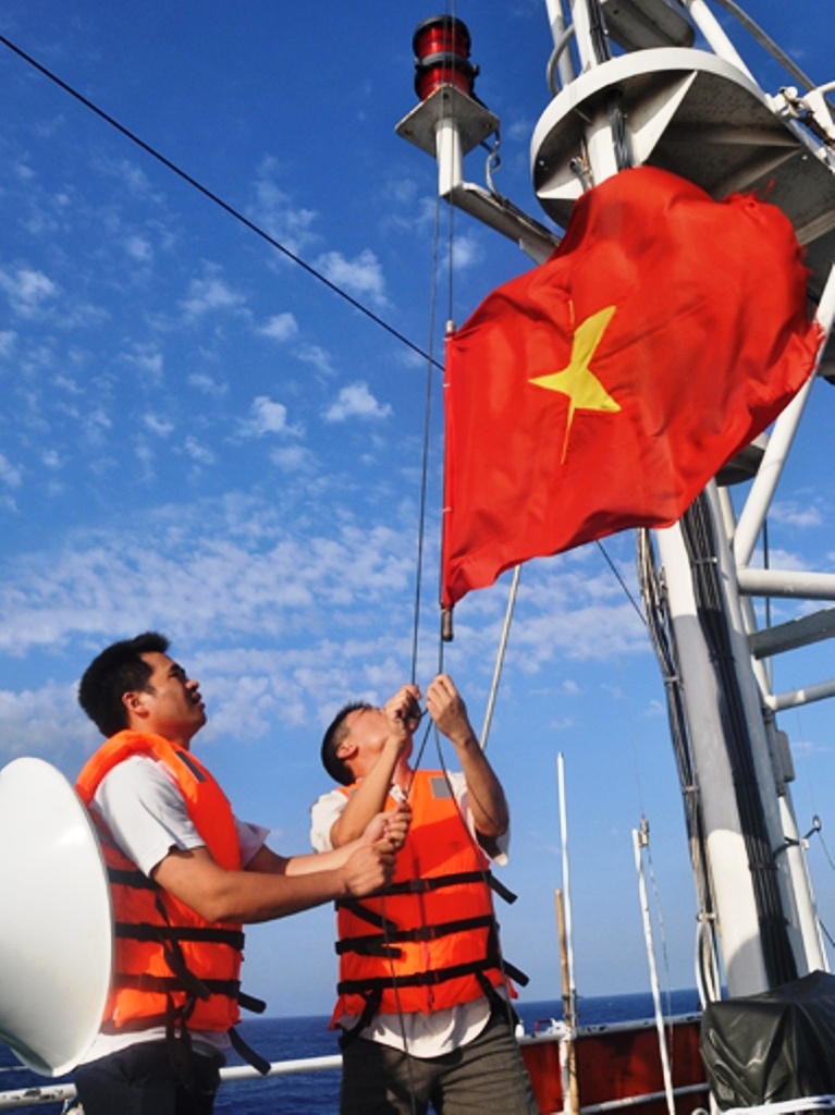 Lá cờ Tổ quốc thiêng liêng được các kiểm ngư viên chỉnh sửa tiếp tục tung bay sau những giờ đấu tranh căng thẳng trên vùng biển Hoàng Sa của Việt Nam.