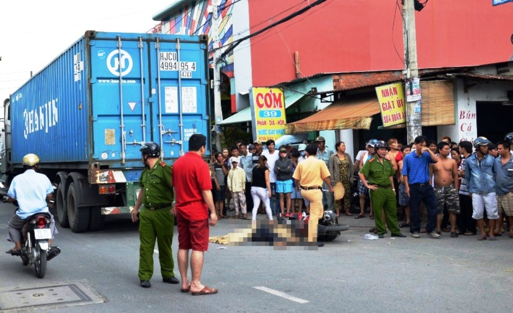 Mot nguoi dan ong tu nan duoi gam xe dau keo hinh anh