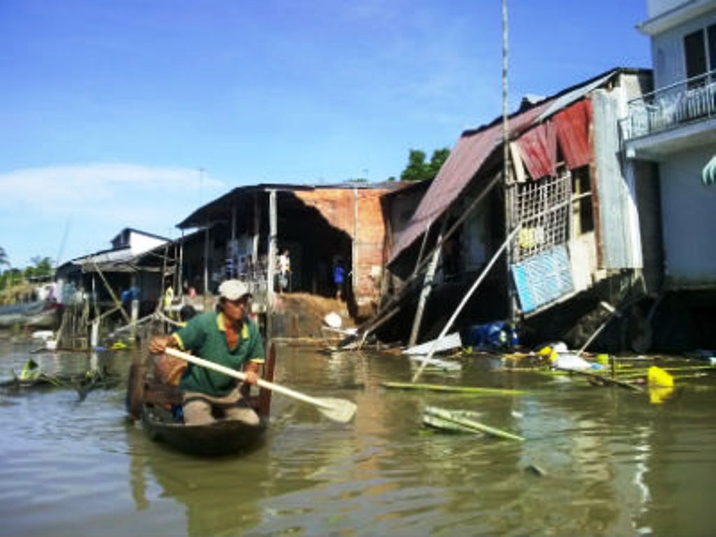 Hang loat nha do sup xuong song, dan cheo thuyen vot do hinh anh