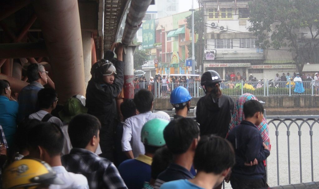 Đến hơn 12h trưa, khu vực cầu Công Lý có mưa rất to khiến hàng trăm người chạy vào gầm cầu trú mưa.