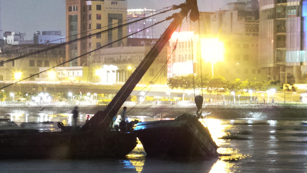 Gần 20h, lực lượng cứu hộ đã kéo nổi một phần sà lan lên khỏi mặt sông.