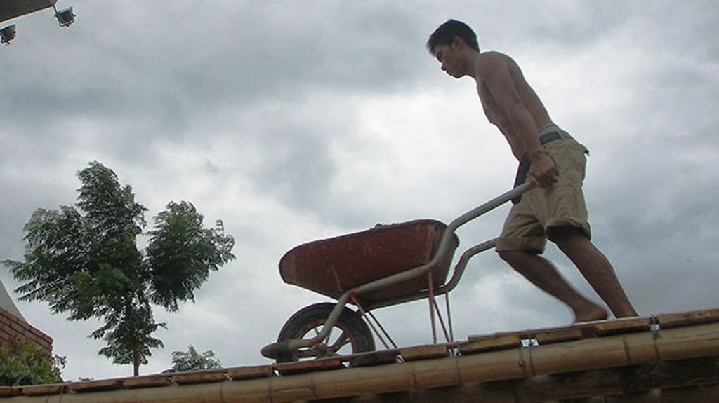 Anh Trần Tân ở phường Phú Hải (TP Đồng Hới) phải dùng xe rùa chở đá xây dựng qua cầu tạm vào nhà