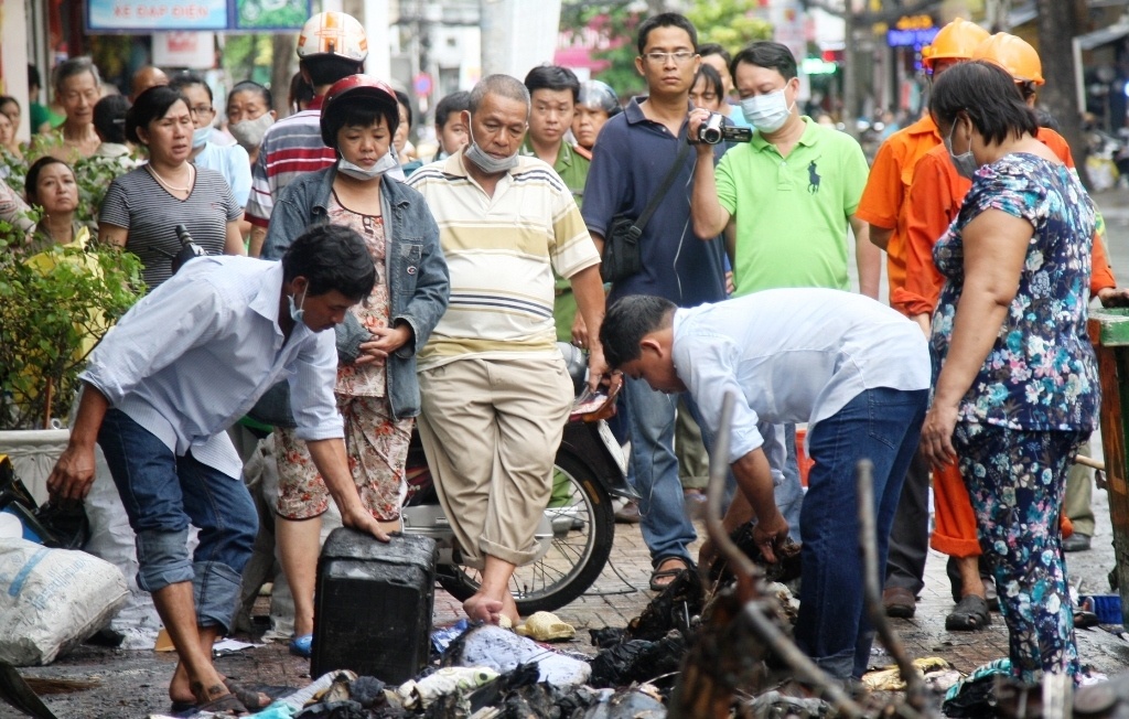 Bà Lan (người đội mũ bảo hiểm) thẩn thờ trước sự mất mát quá lớn.