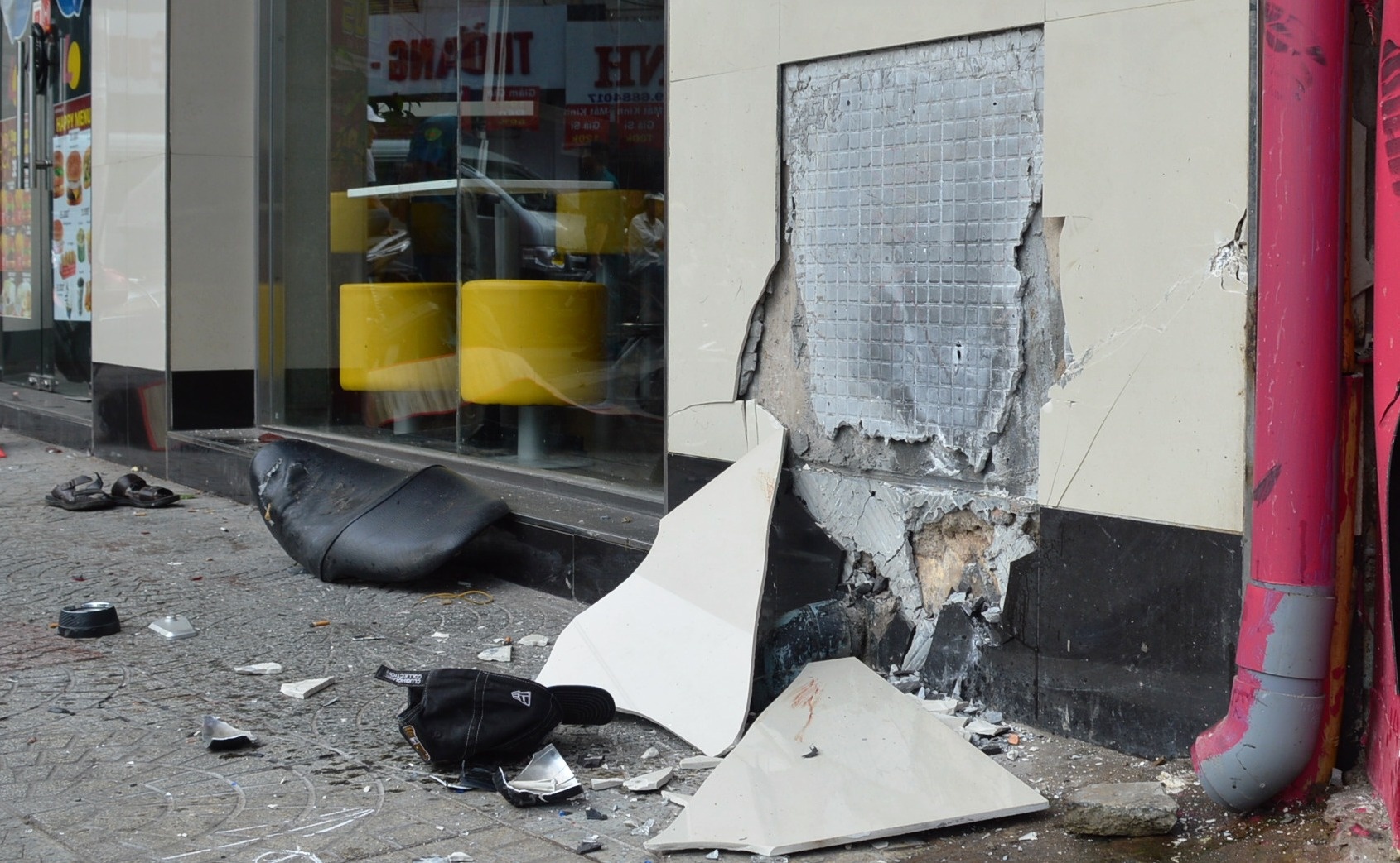 Một mảng gạch hoa ốp tường củ quán thức ăn nhanh bị vỡ sau cú tông mạnh của chiếc môtô phân khối lớn.