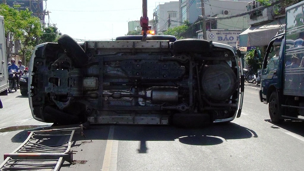 Oto lat ngang giua duong, hai nguoi may man thoat nan hinh anh