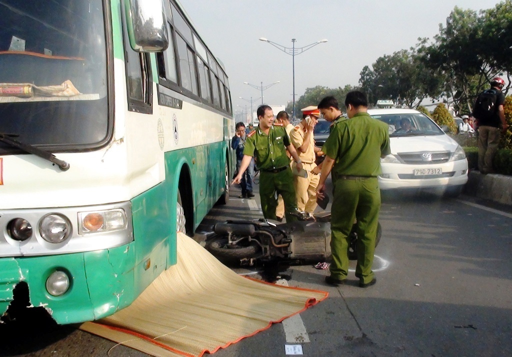 Thi the thanh nien mac ket duoi banh xe buyt o Sai Gon hinh anh