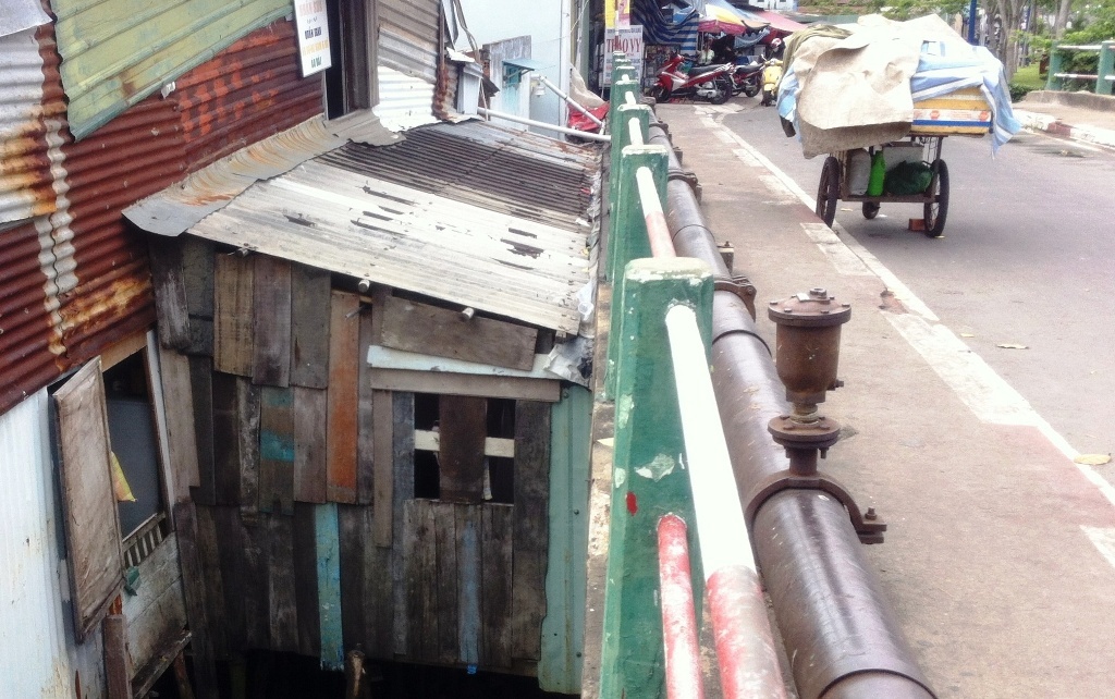 Căn nhà chưa đầy 15m2, lụp xụp dưới chân cầu Dừa là nơi 13 thành viên gia đình ông Minh sinh sống.