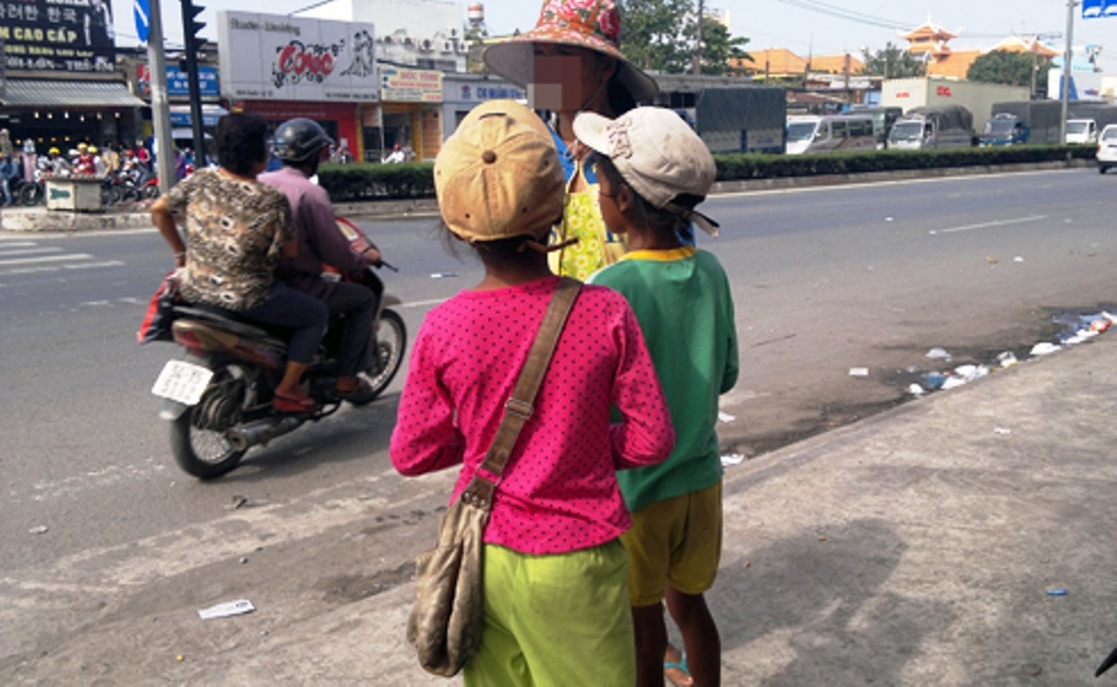 Người phụ nữ và hai bé gái ăn xin tại ngã tư Trung Chánh.