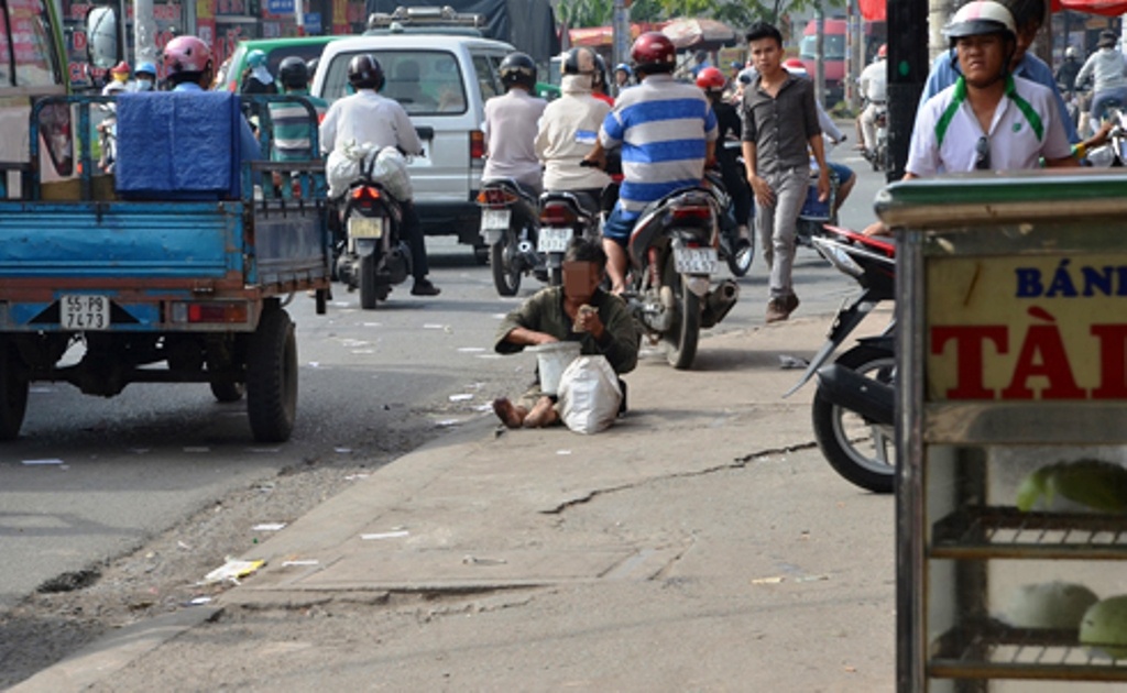 Thấy tiền trong thùng nhựa khá nhiều, người đàn ông ngồi xếp tiền ngay trên vỉa hè.
