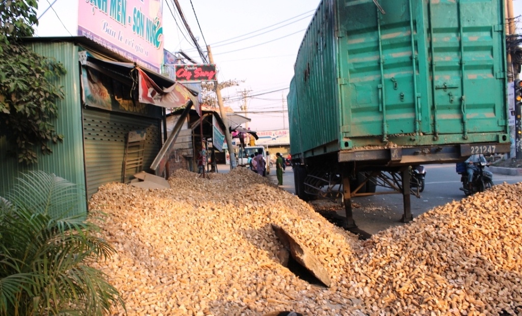 Hiện trường vụ xe đầu kéo lật khiến hàng chục tấn khoai mì khô bít cửa nhà dân.