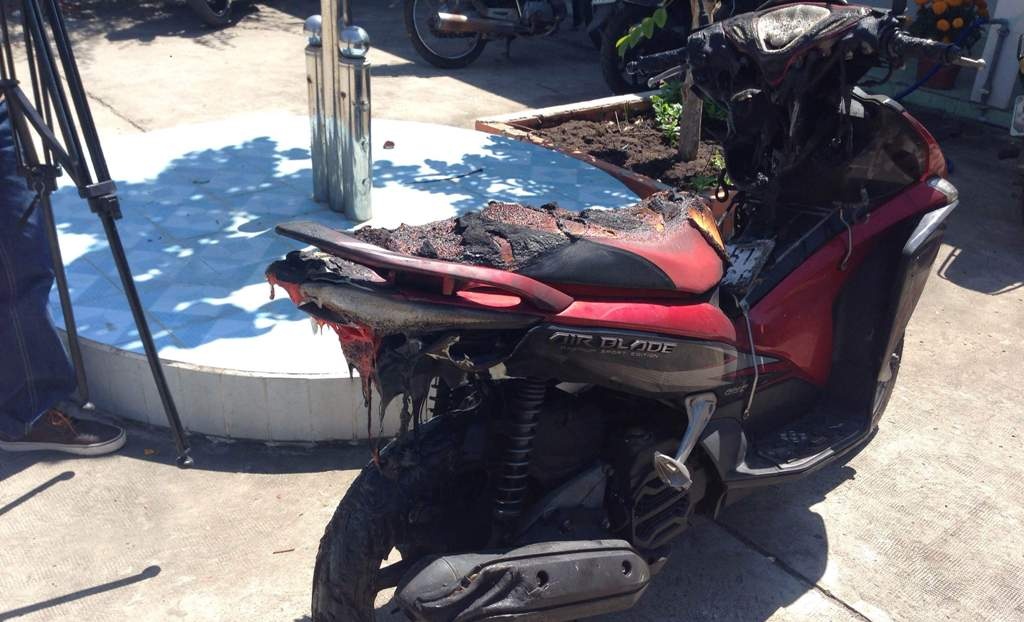 Chiếc xe máy bên trong phòng trọ bị ngọn lửa bén tới cháy làm hư hỏng nặng.