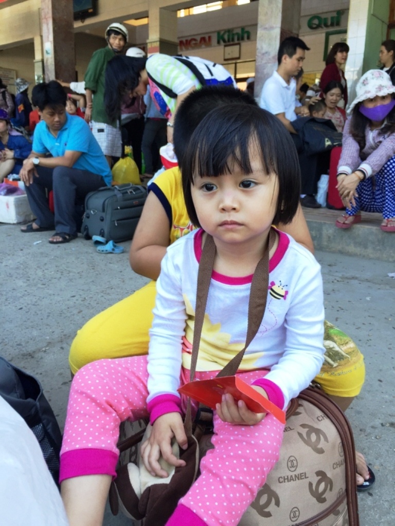 Trẻ em cũng phải chịu cảnh vất vả đợi tàu, xe tại bến cùng với cha mẹ.