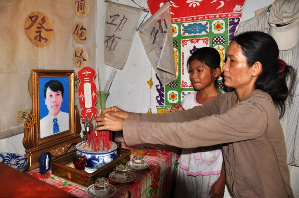 Chị Nga bên bàn thờ  chồng mình, anh Phạm Vinh - người thợ lặn  ở Lý Sơn đã tử nạn khi lặn quy tập hài cốt liệt sĩ ở biển Gạc Ma.