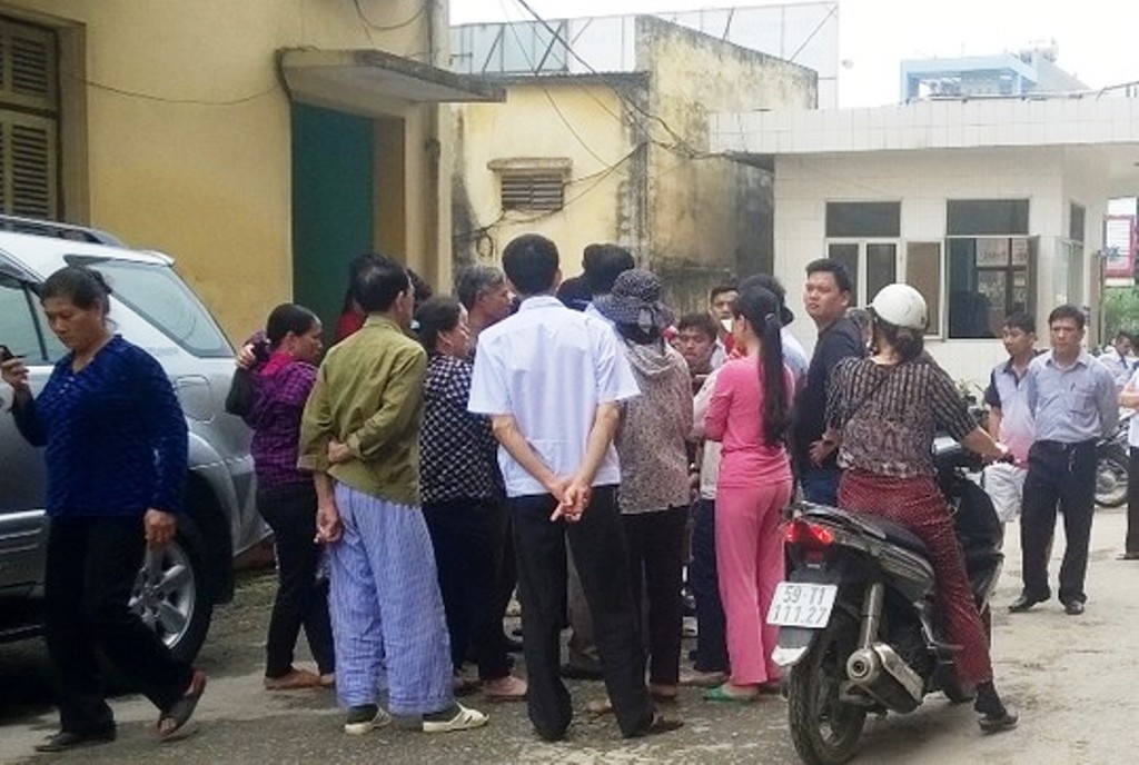 Người dân tụ tập trước cổng nhà khác 25A theo dõi cơ quan chức năng khám nghiệm hiện trường.