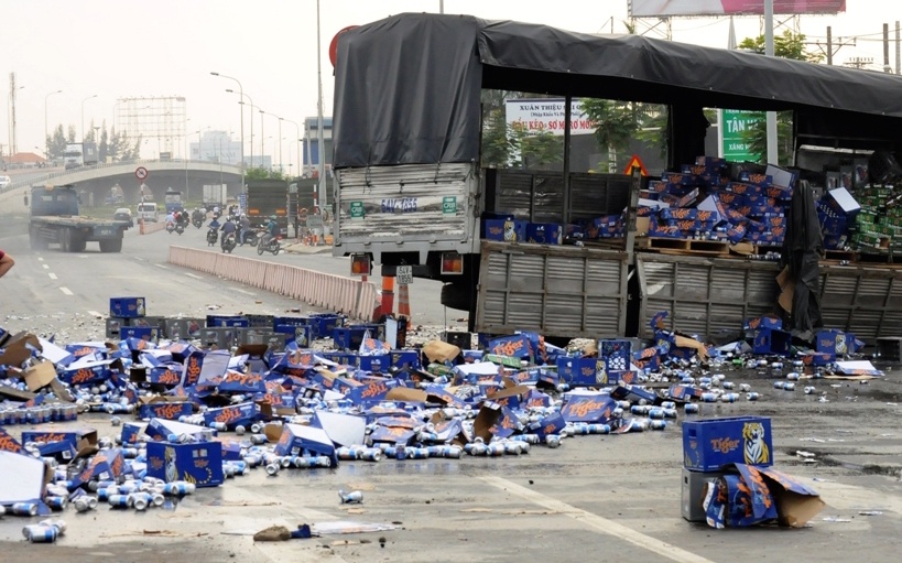 Nguoi dan giup tai xe gom hang ngan chai bia roi ra duong hinh anh