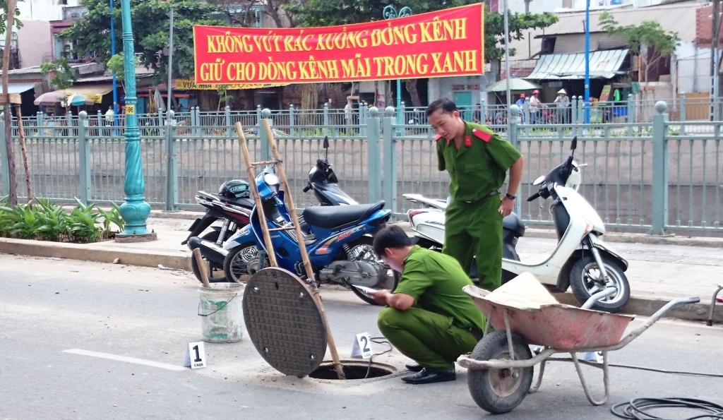Lực lượng công an quận 6 khám nghiệm hiện trường nơi hố ga phát nổ.