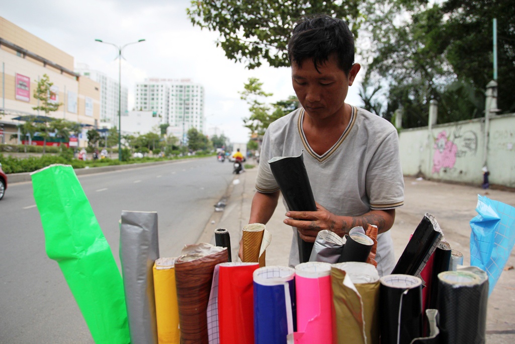 Công việc dán decal ế ẩm, nhiều hôm anh Tuấn phải phụ bưng bê hủ tiếu để có cái ăn qua ngày.