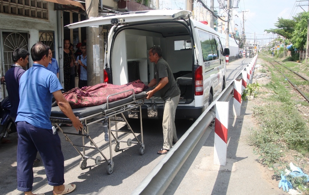 Nguoi dan ong dung giua duong ray khi tau hoa lao toi hinh anh