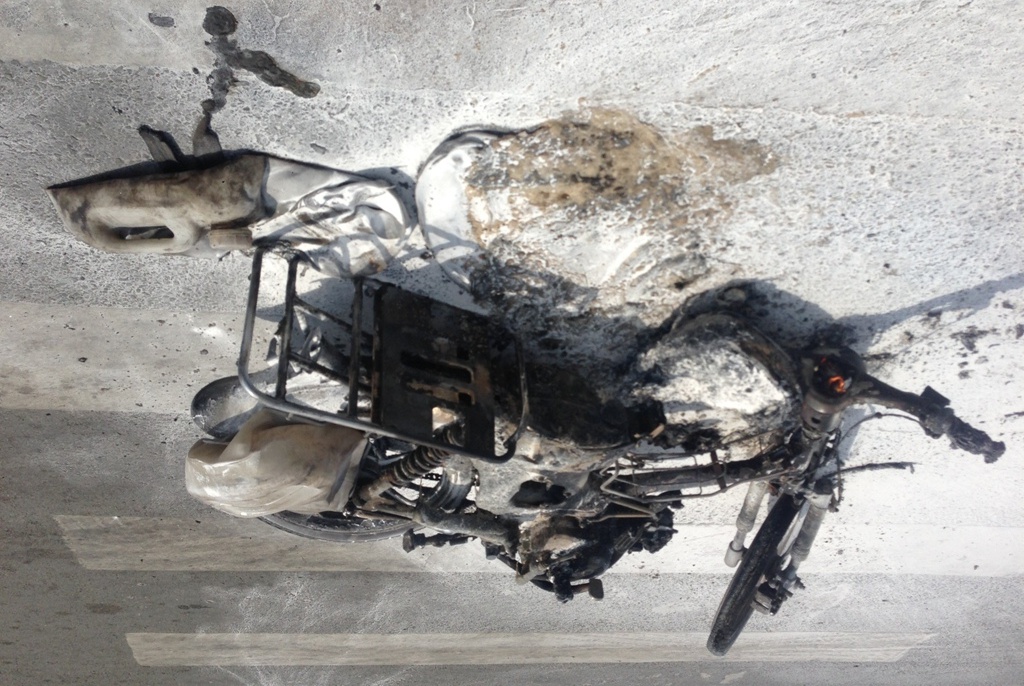 Trong ít phút, chiếc xe máy cháy rụi, trơ khung.