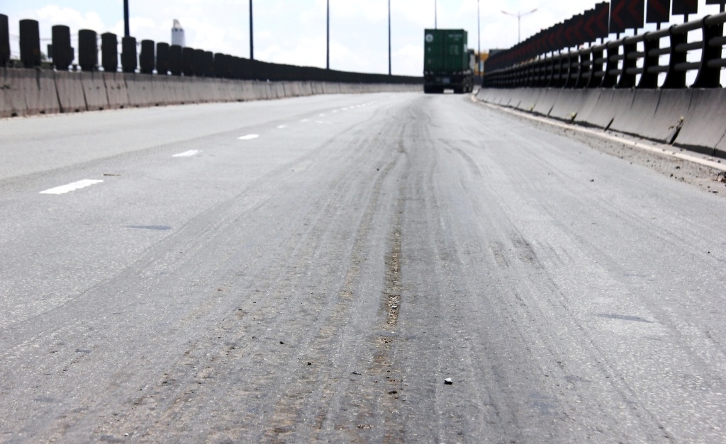 Những vết cào sửa chữa trồi lún nhựa trên mặt cầu vượt bằng thép Thủ Đức. 