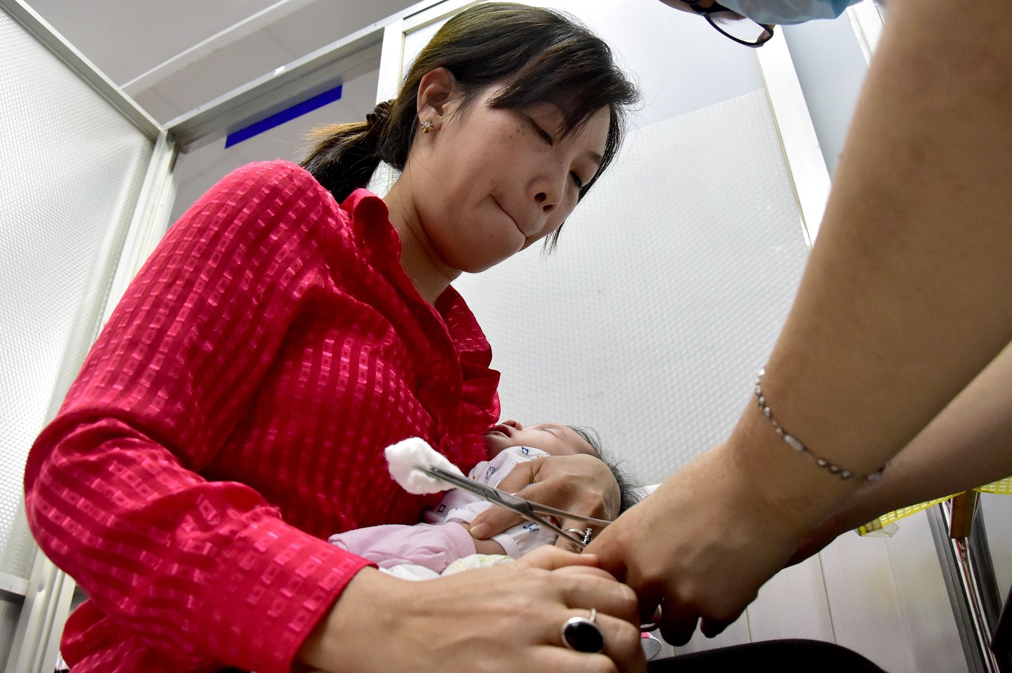 Con chị Huyền, quận 2, TP HCM được đến lượt tiêm. Mắt người mẹ này thâm cuồng vì đến trung tâm từ 1h30 sáng để chờ, đến 8h30 mới đến lượt tiêm.