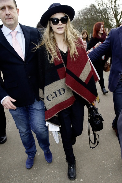 Người mẫu Cara Delevingne với chiếc poncho có thêu tên viết tắt của mình.