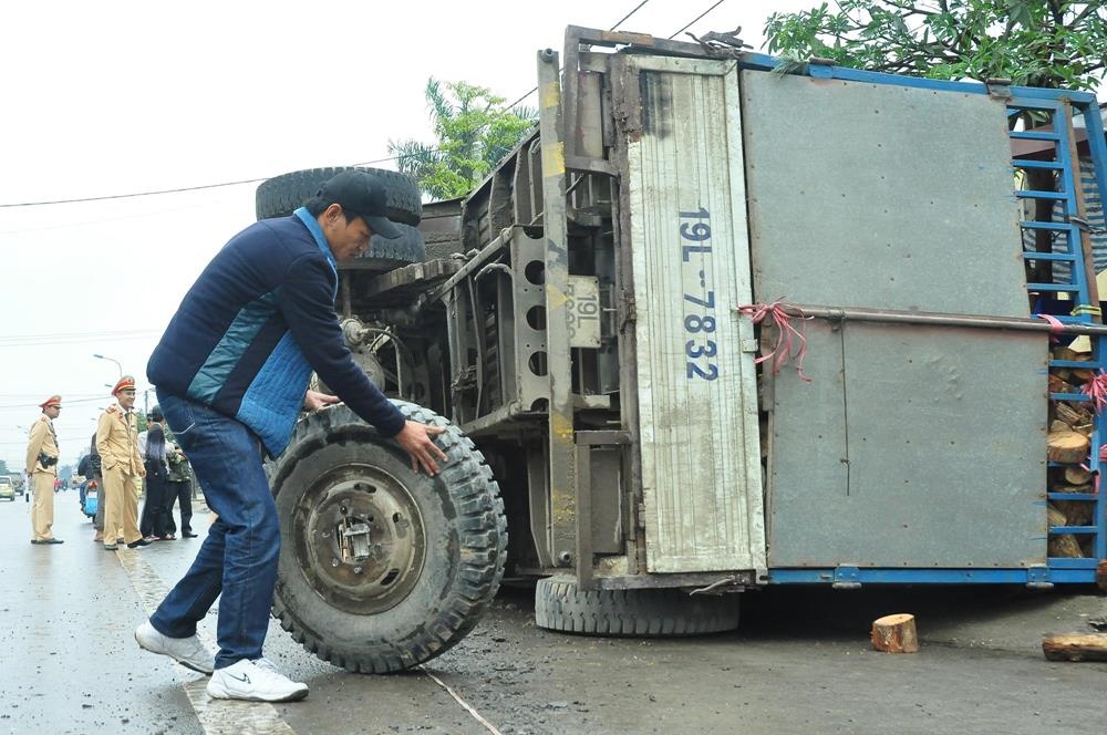 Vang banh sau khi dang chay, xe tai cho go bi lat giua duong hinh anh