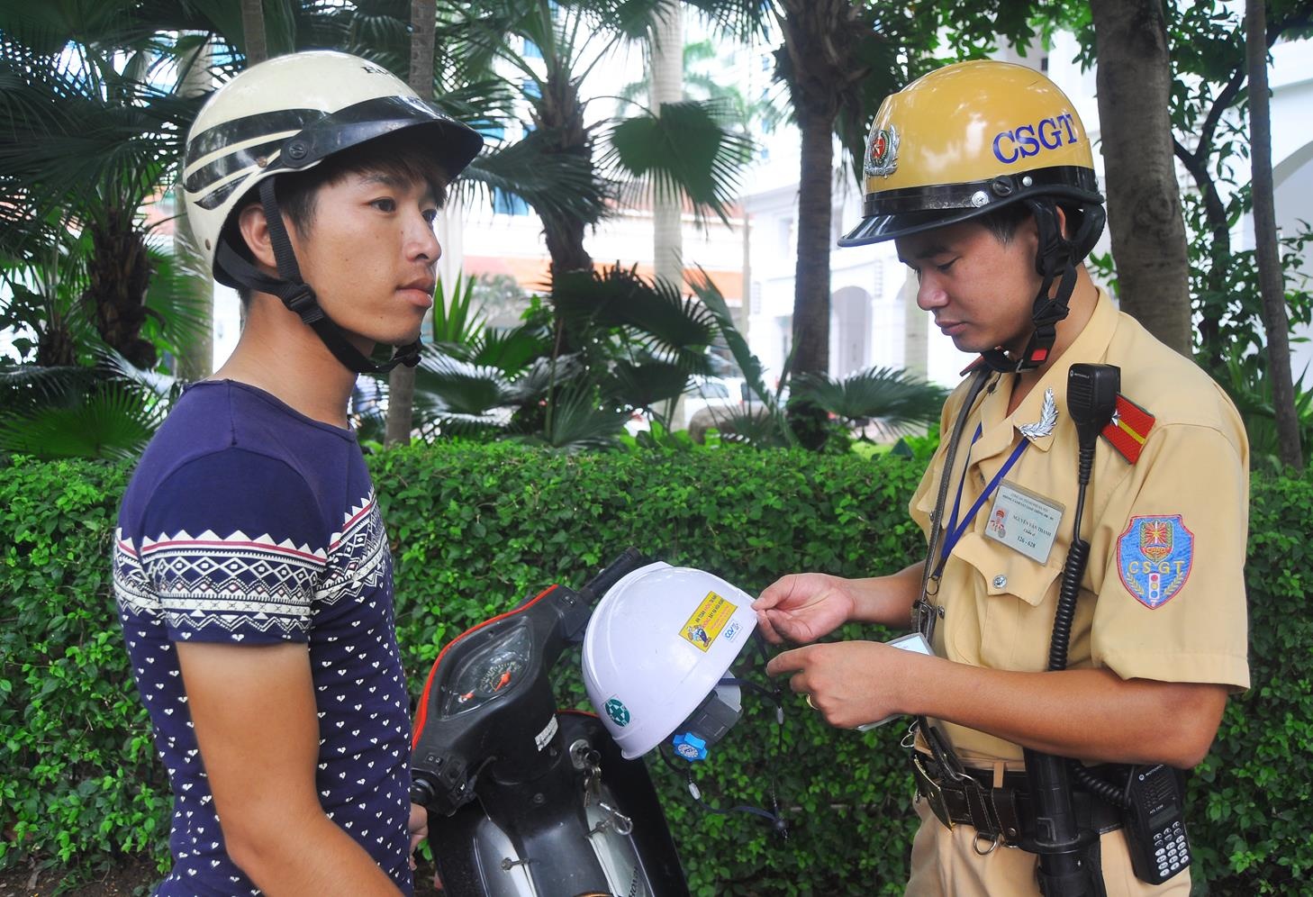 Lực lượng CSGT tiến hành nhắc nhở, xử lý người ham gia giao thông đội mũ bảo hiểm không đạt chuẩn.