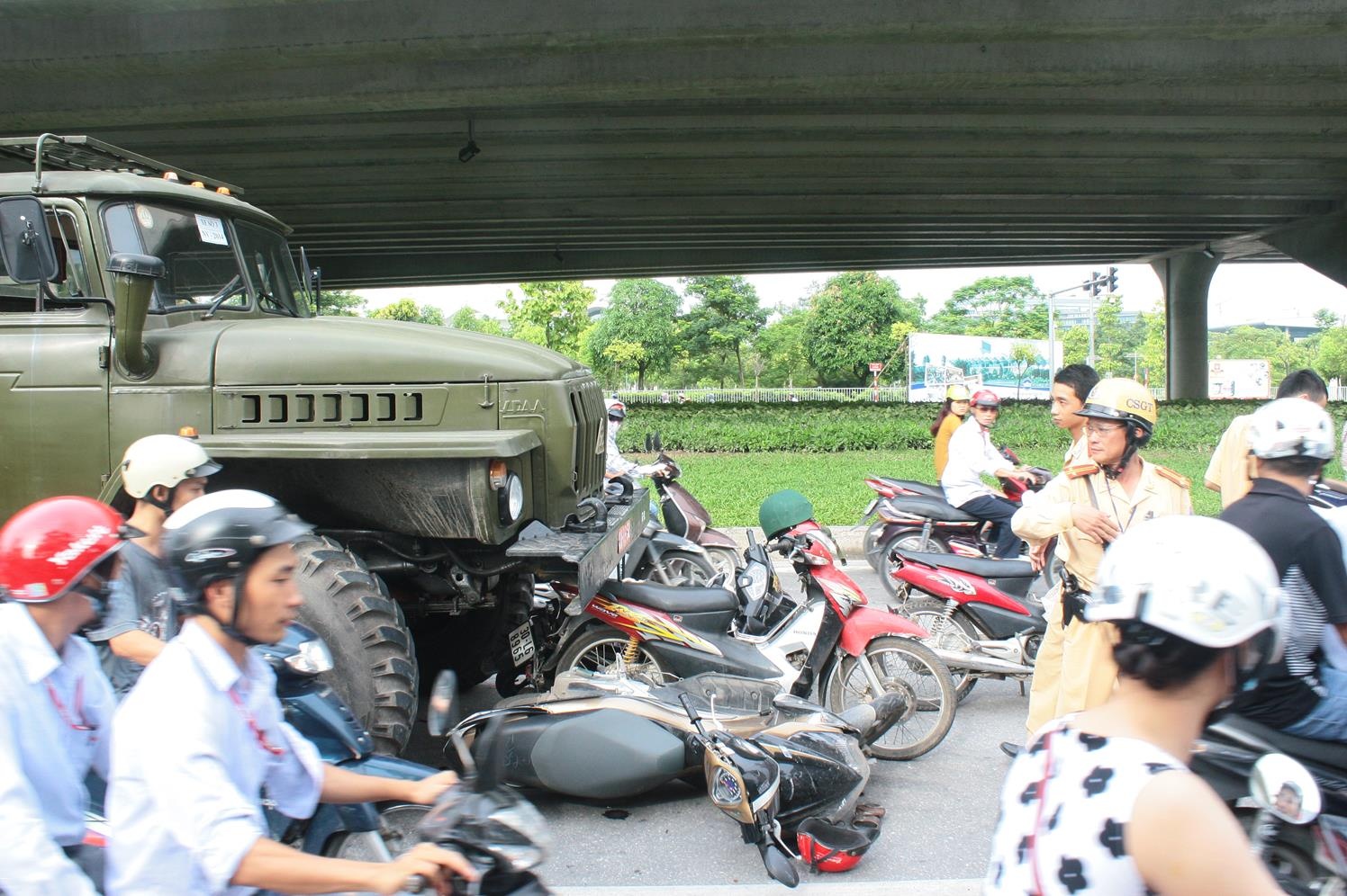 Tại hiện trường, 4 chiếc xe máy vẫn nằm dưới gầm chiếc ô tô tải biển đỏ.