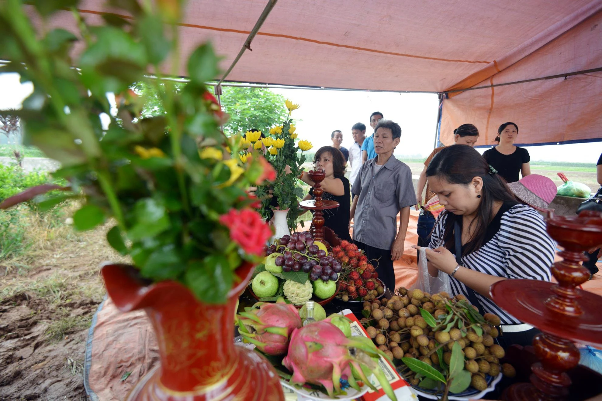 Mang theo nhứng đóa cúc vàng cùng bánh trái mà người cháu thích ăn bà Bảy cùng các bác, các dì và anh chị em lặng lẽ xuống thăm mộ phần của cháu gái.