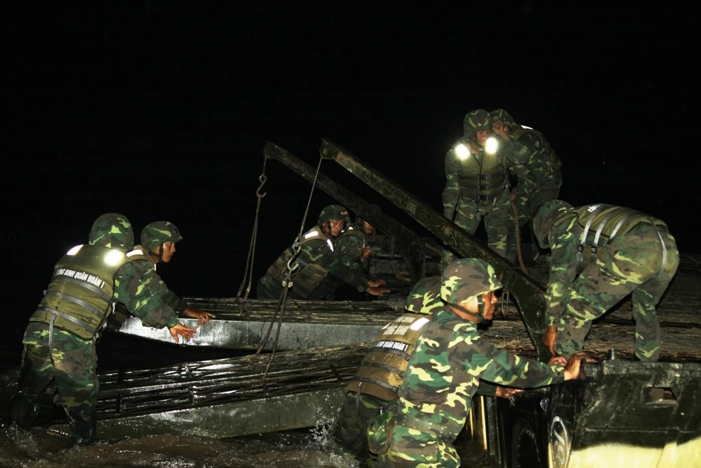 Trong đêm tối lực lượng công binh lắp ghép phà và cầu phao bảo đảm cho các phương tiện vượt sông.