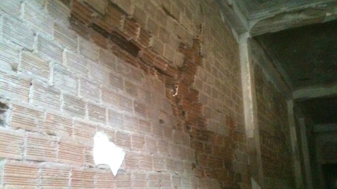 Vách nhà bị nứt sau trận cháy. - Ảnh: Hoàng Thạch