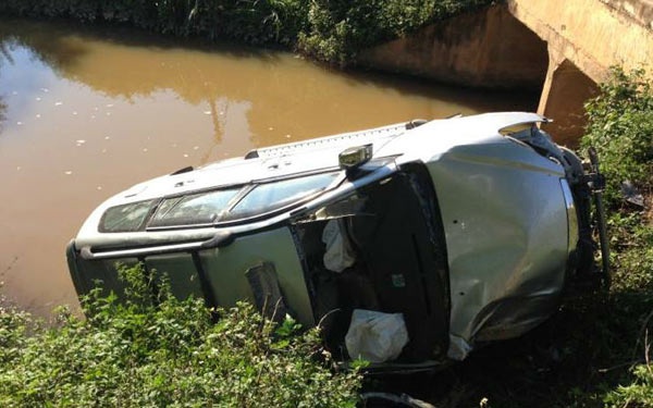 Tại hiện trường, chiếc xe lật nghiêng trên bờ cỏ sát bên nhà dân, một phần đuôi xe chìm dưới nước.  Phần đầu xe bị hư hỏng khá nặng, bánh xe cùng gầm trước mui xe bị vỡ, rơi ra ngoài.