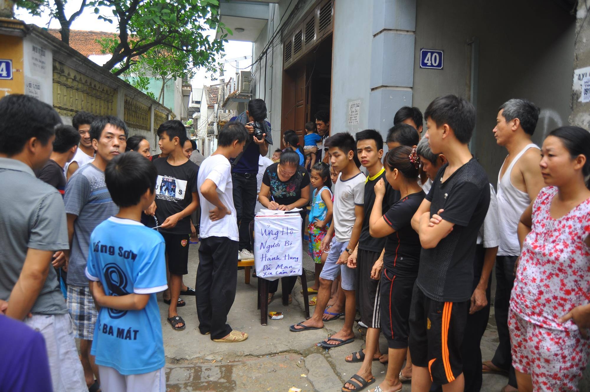 Người dân quyên góp tiền giúp nạn nhân. Ảnh: Hoàn Nguyễn.