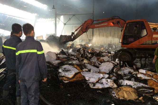 Các lực lượng chức năng thu dọn hiện trường vụ cháy. (Ảnh: Lâm Hoài)