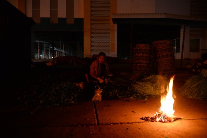 Ngọn lửa ấm của bà Nguyễn Thị Mười nhặt rau muống thuê tại chợ đầu mối Bình Điền (Q.8).