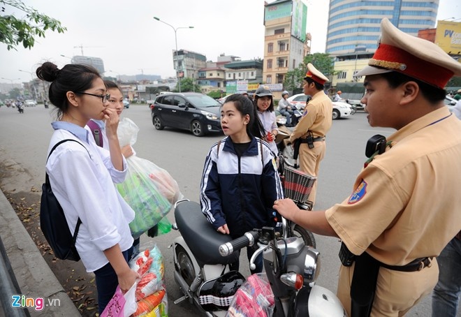 Phụ huynh, học sinh ngồi trên xe máy, lái xe đạp điện không đội mũ bảo hiểm sẽ bị phạt tiền từ ngày 10/4. Ảnh: Lê Hiếu.