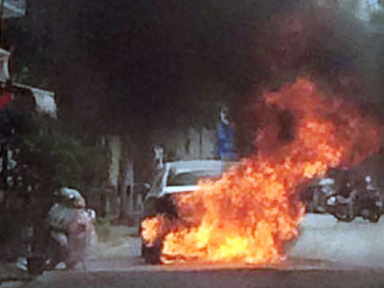 Nguoi dan ong dap cua oto boc chay thoat than hinh anh