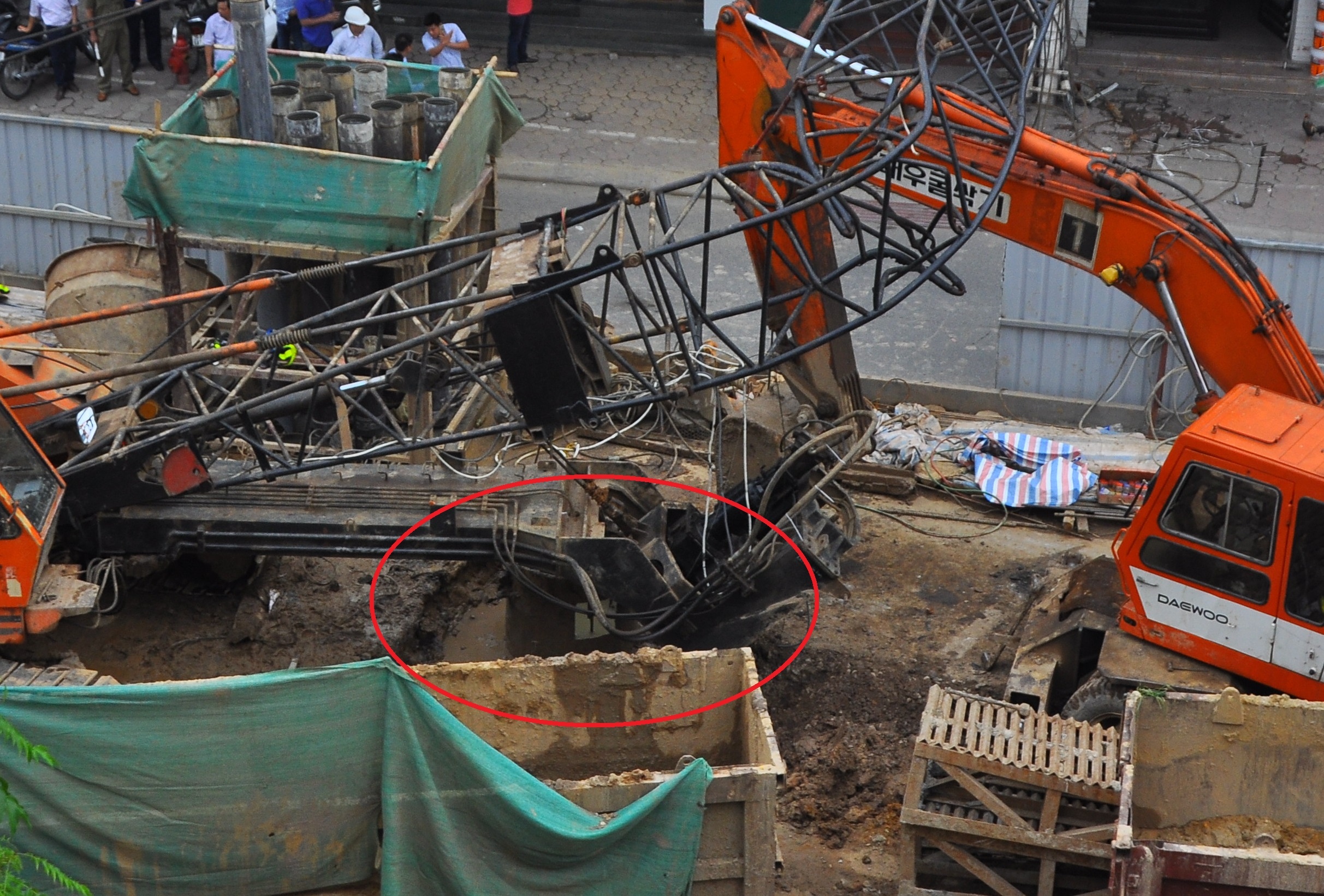 Khi rút ông vách (trong vùng khoanh đỏ), do không lường trước lực ma sát giữa đất và ống dẫn đến cần cẩu bị đổ. Ảnh: Hoàn Nguyễn