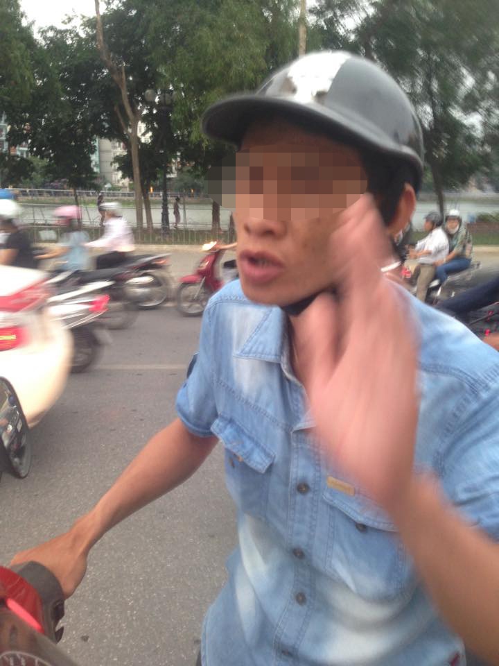 Thanh niên này nhiều lần chặn ôtô dừng đèn đỏ xin tiền. Ảnh: Đỗ Hào.